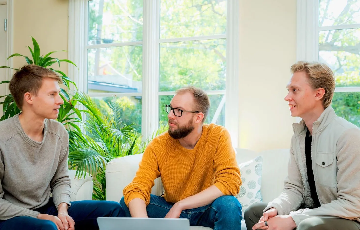 Solu's founding team sitting on sofas, looking at a laptop.